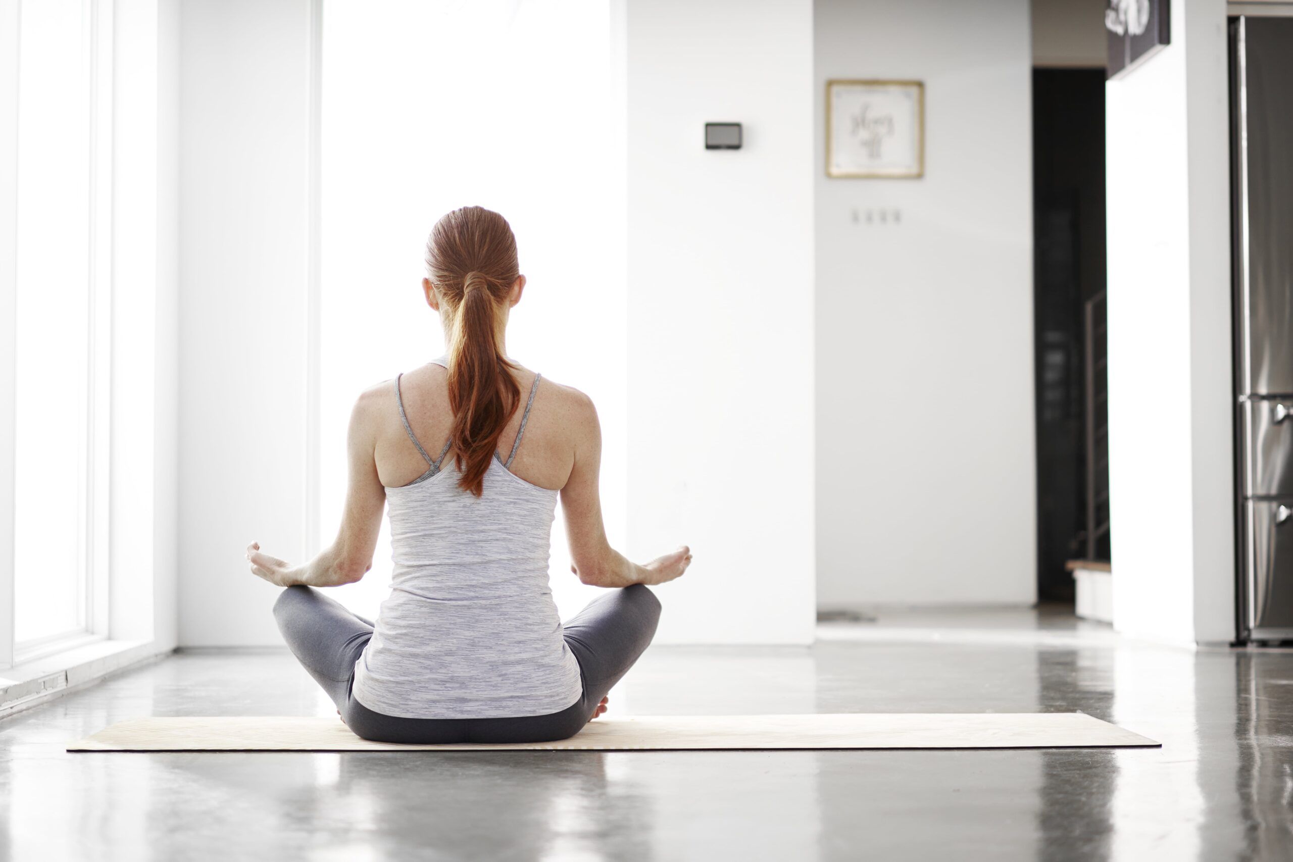 Femme pratiquant le yoga dans une pièce à température contrôlé.